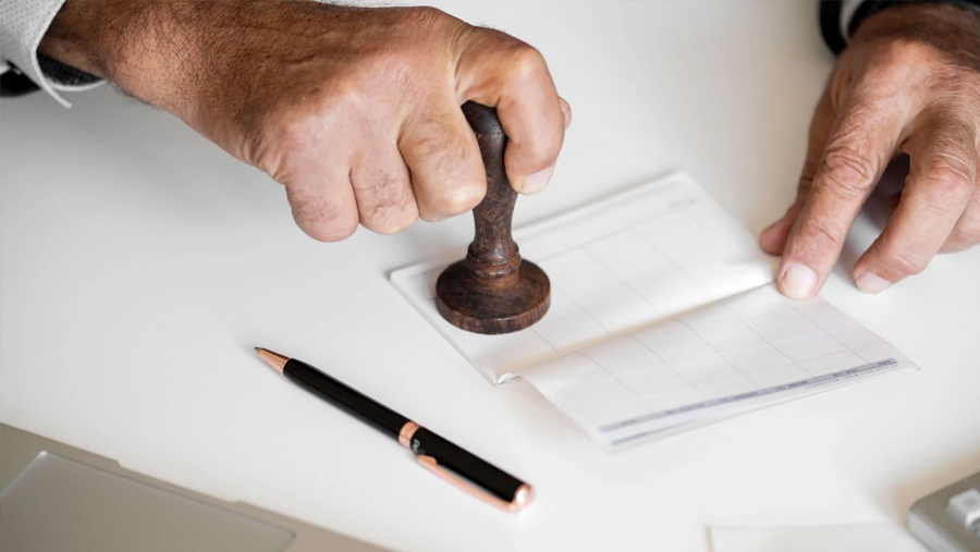 Closeup of a man's hands, putting a seal on a document