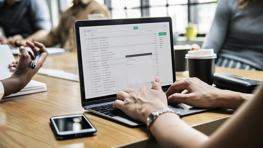 Mid shot of a woman working on her laptop in a meeting room environment