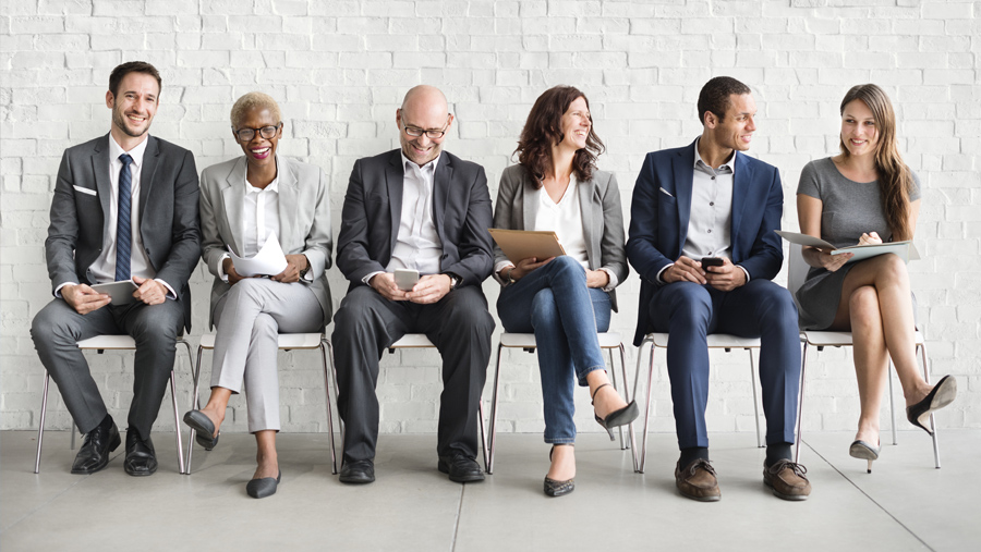 A group of diverse coworkers sitting in chairs, looking happy