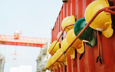 Multiple hard hats hanging on a wall in a construction site environment