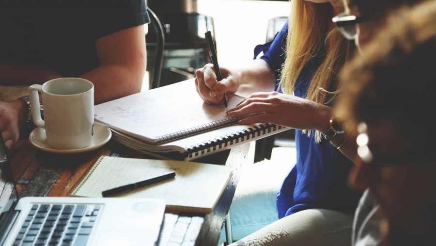 Closeup of a group of diverse persons working together in a table